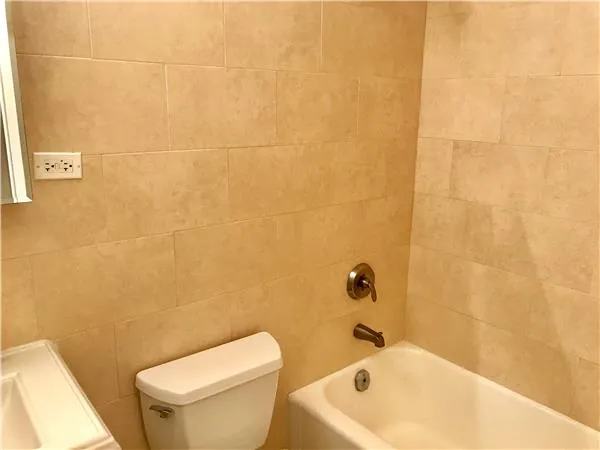 a white bath tub sitting next to a white toilet and sink