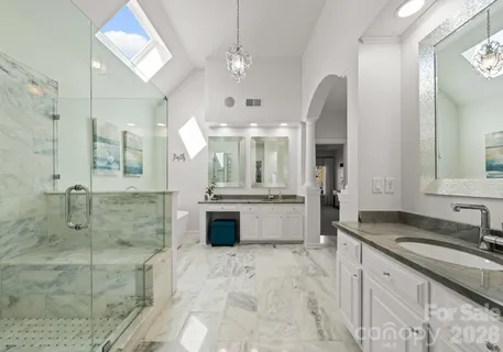 a large bathroom with a granite countertop double vanity sink a mirror and a bathtub