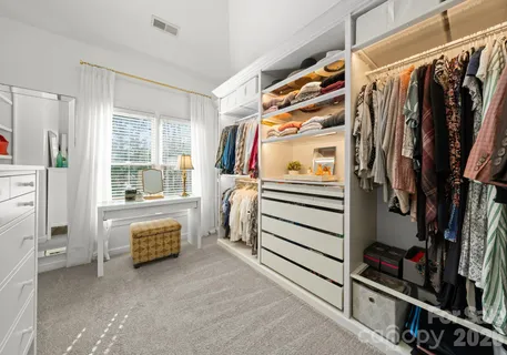 a view of walk in closet with clothes and shoes