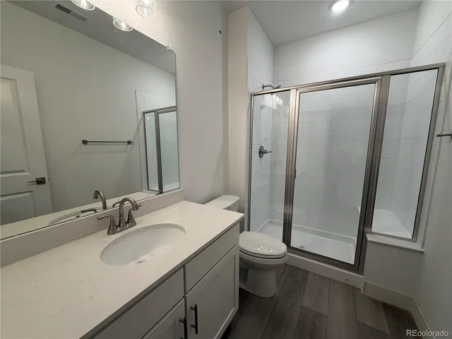 a bathroom with a double vanity sink toilet and shower