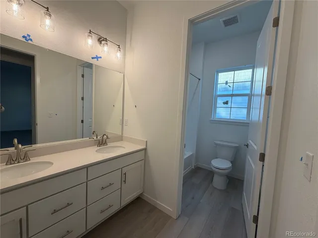 a bathroom with a double vanity sink toilet and a mirror