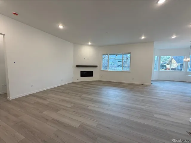 an empty room with wooden floor and window