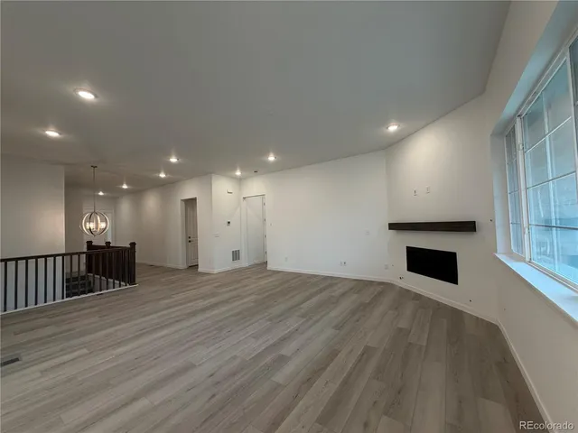 an empty room with wooden floor and fireplace