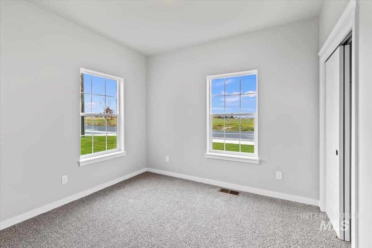 1228 Creekside Way Twin Falls, ID 83301 - Photo 12 of 28 Unfurnished bedroom with light carpet, multiple windows, and a closet