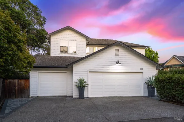 a front view of a house with a garage and yard