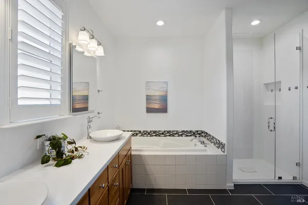 a en suite bathroom with a granite countertop sink and a mirror