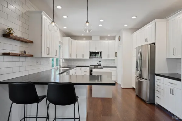 a kitchen with appliances a refrigerator and cabinets