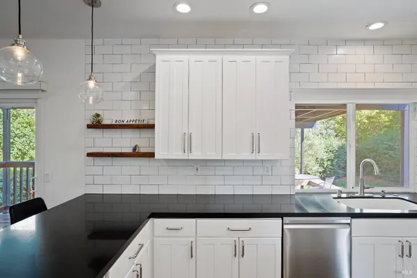 a kitchen with stainless steel appliances a stove a microwave and sink