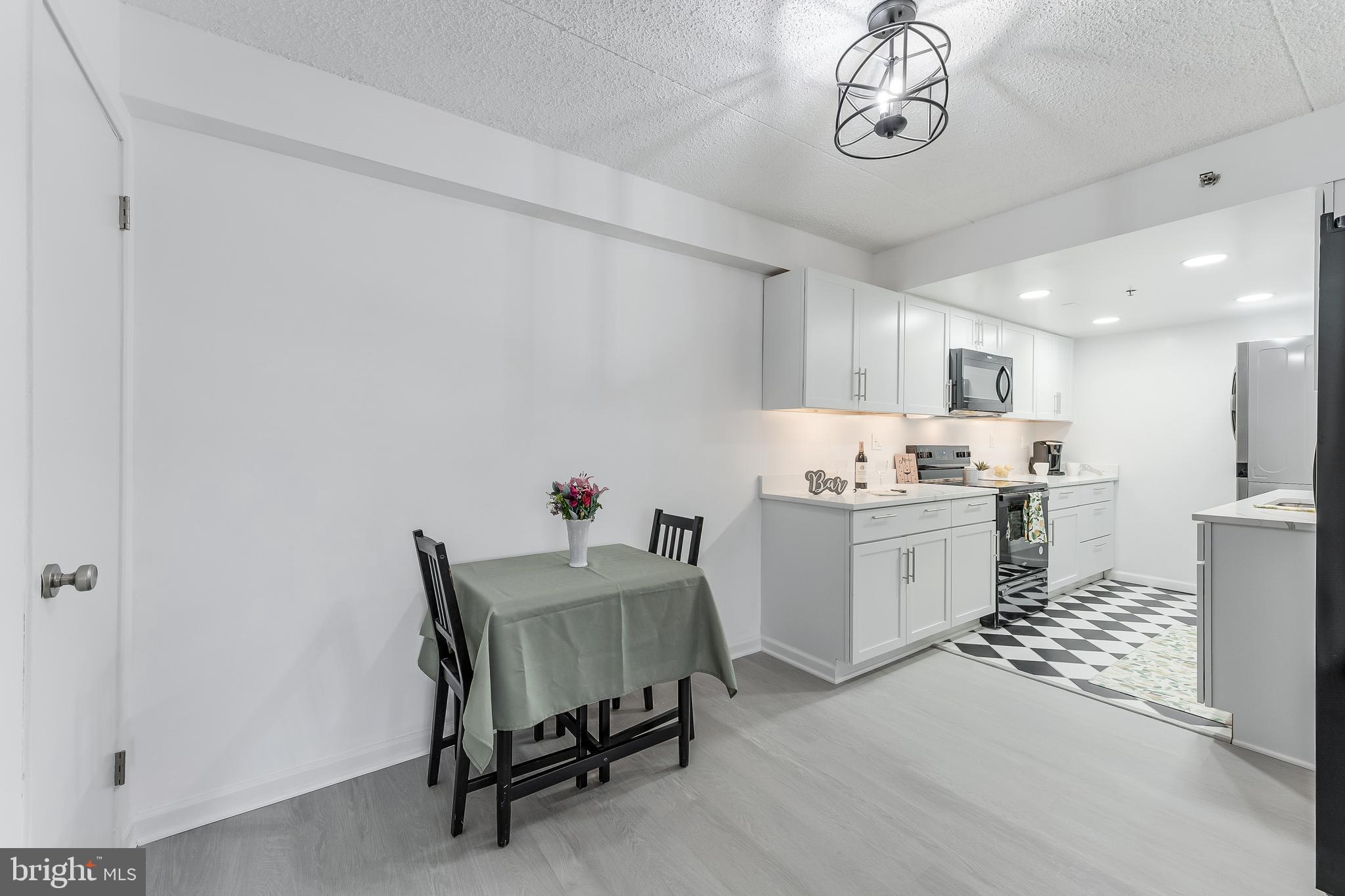 5911 Edsall Road, Unit 708 Alexandria, VA 22304 - Photo 8 of 39 a kitchen with a refrigerator and a table