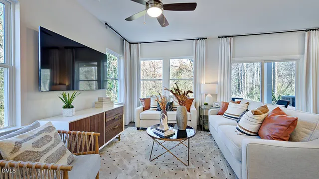 a living room with furniture a refrigerator and kitchen view
