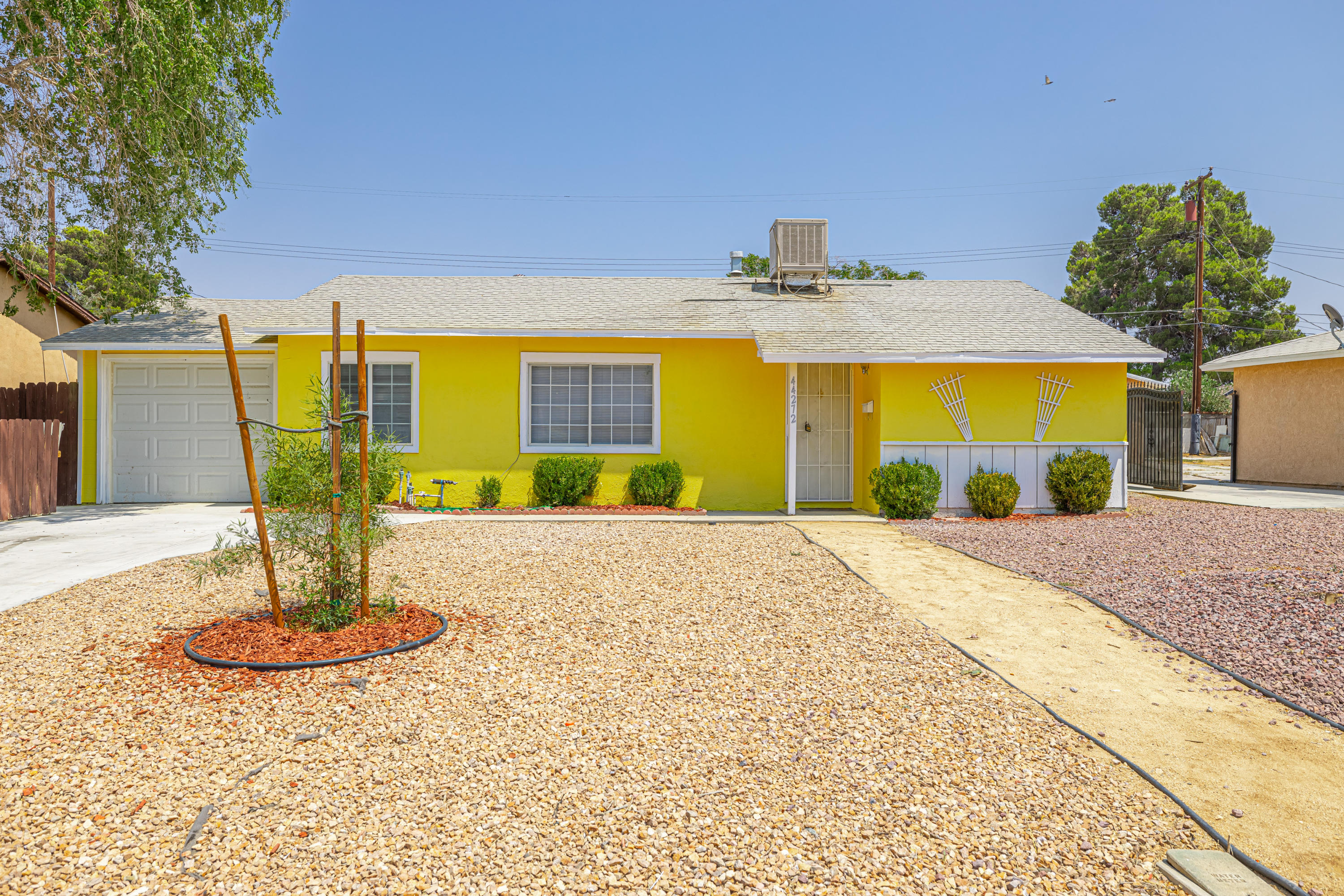 44272 Glenraven Road Lancaster, CA 93535 - Photo 1 of 21 a front view of a house with a yard and a garage