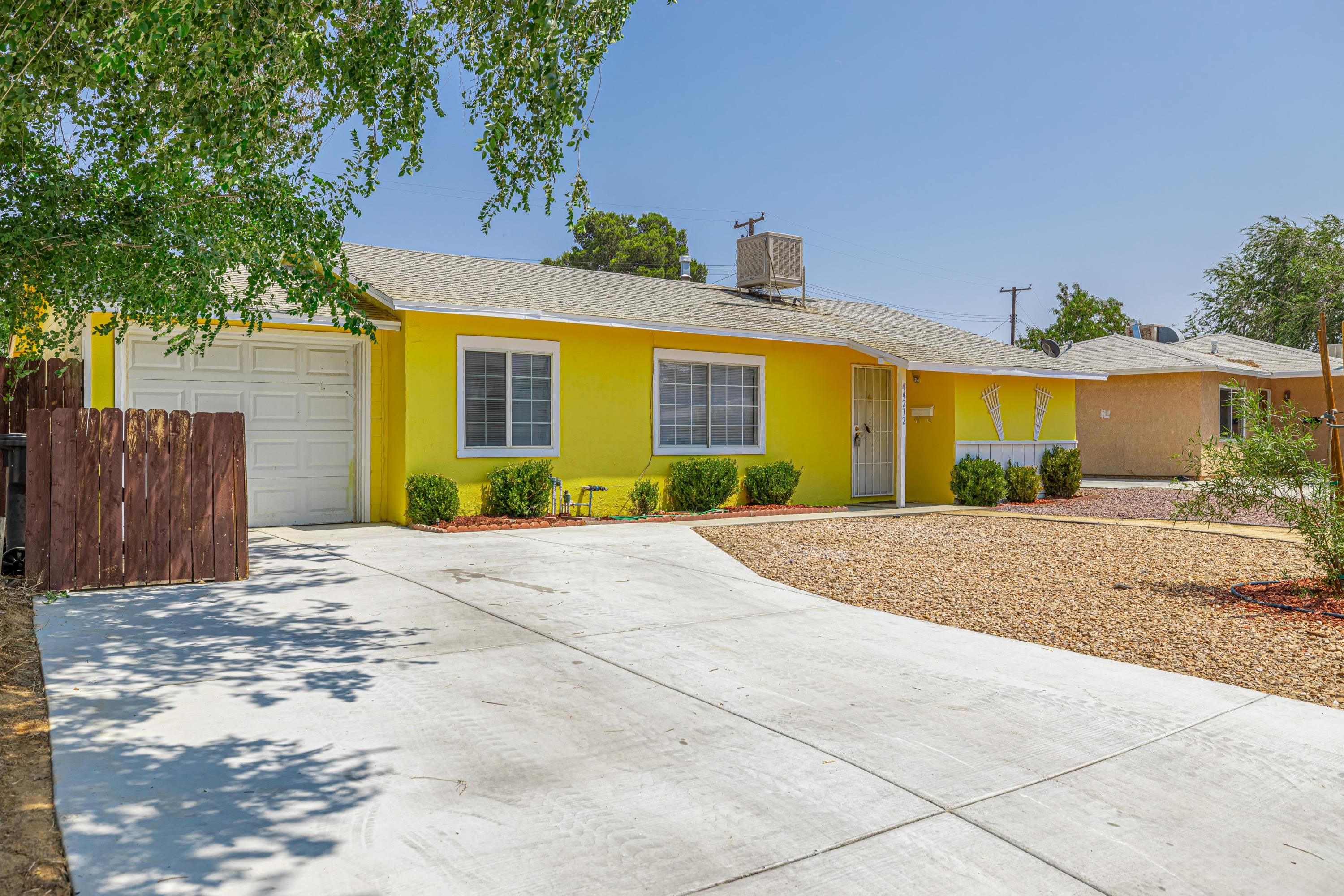 44272 Glenraven Road Lancaster, CA 93535 - Photo 2 of 21 a front view of a house with a yard and a garage