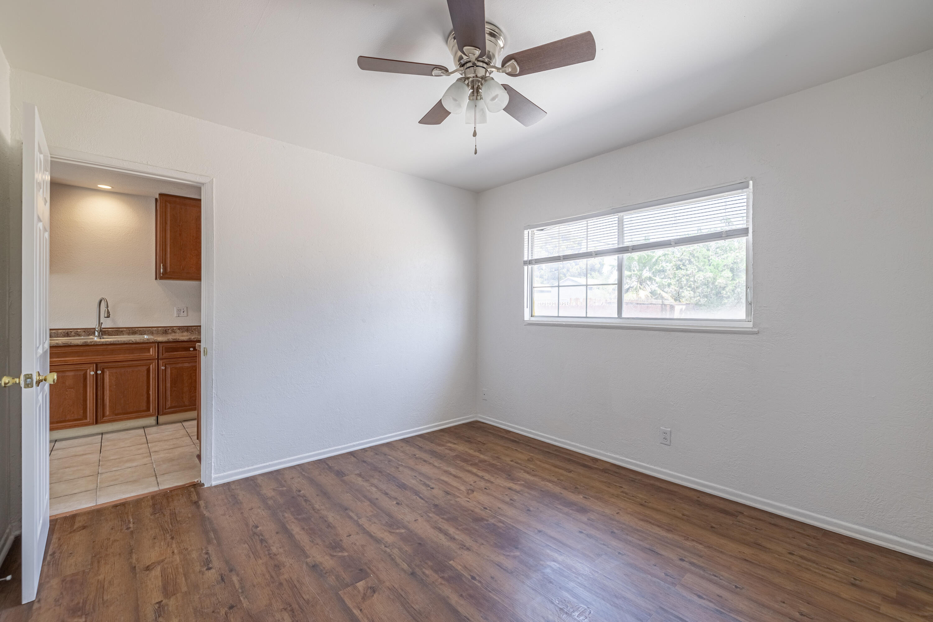 44272 Glenraven Road Lancaster, CA 93535 - Photo 12 of 21 a view of empty room with wooden floor and kitchen view