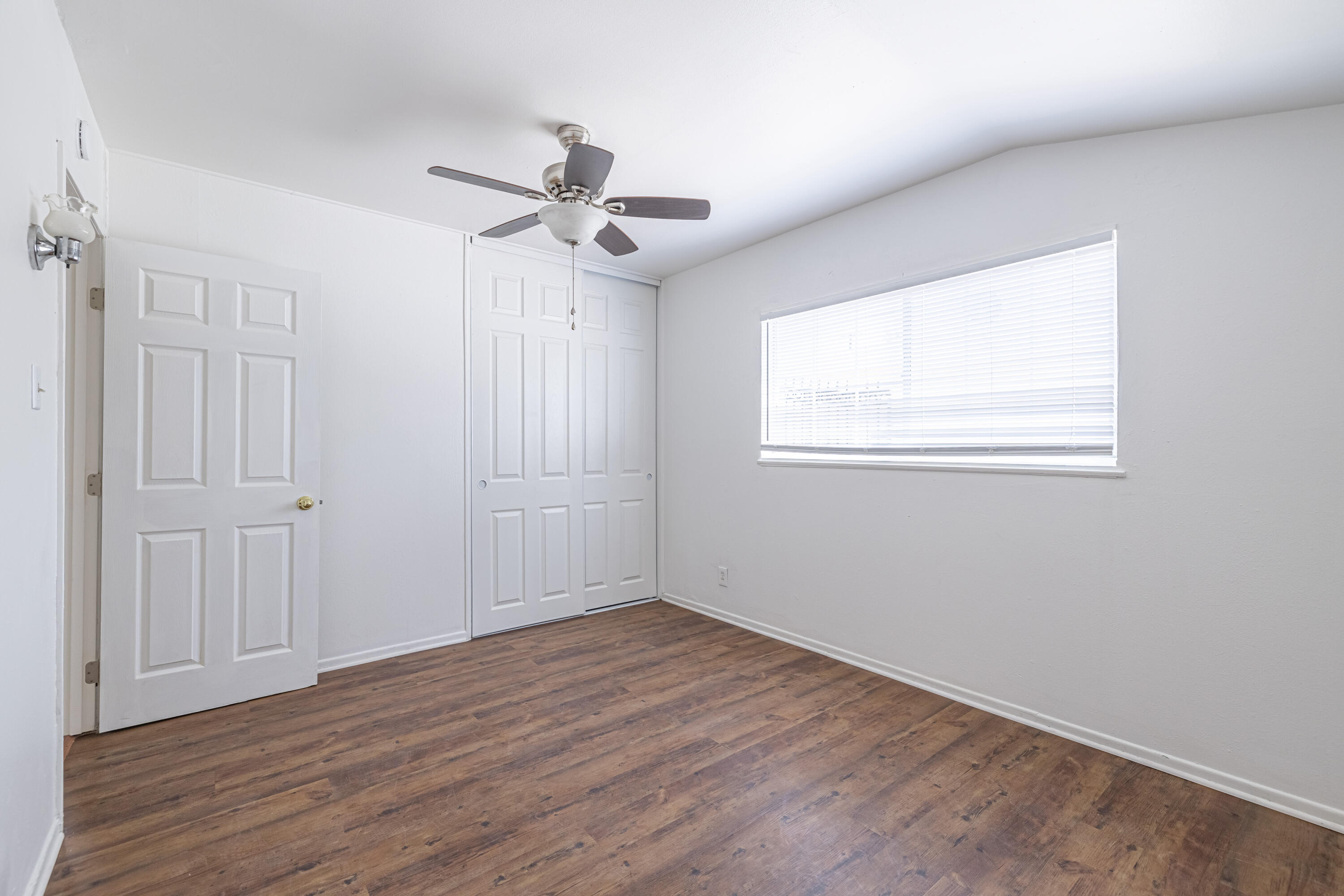 44272 Glenraven Road Lancaster, CA 93535 - Photo 15 of 21 an empty room with wooden floor chandelier fan and windows