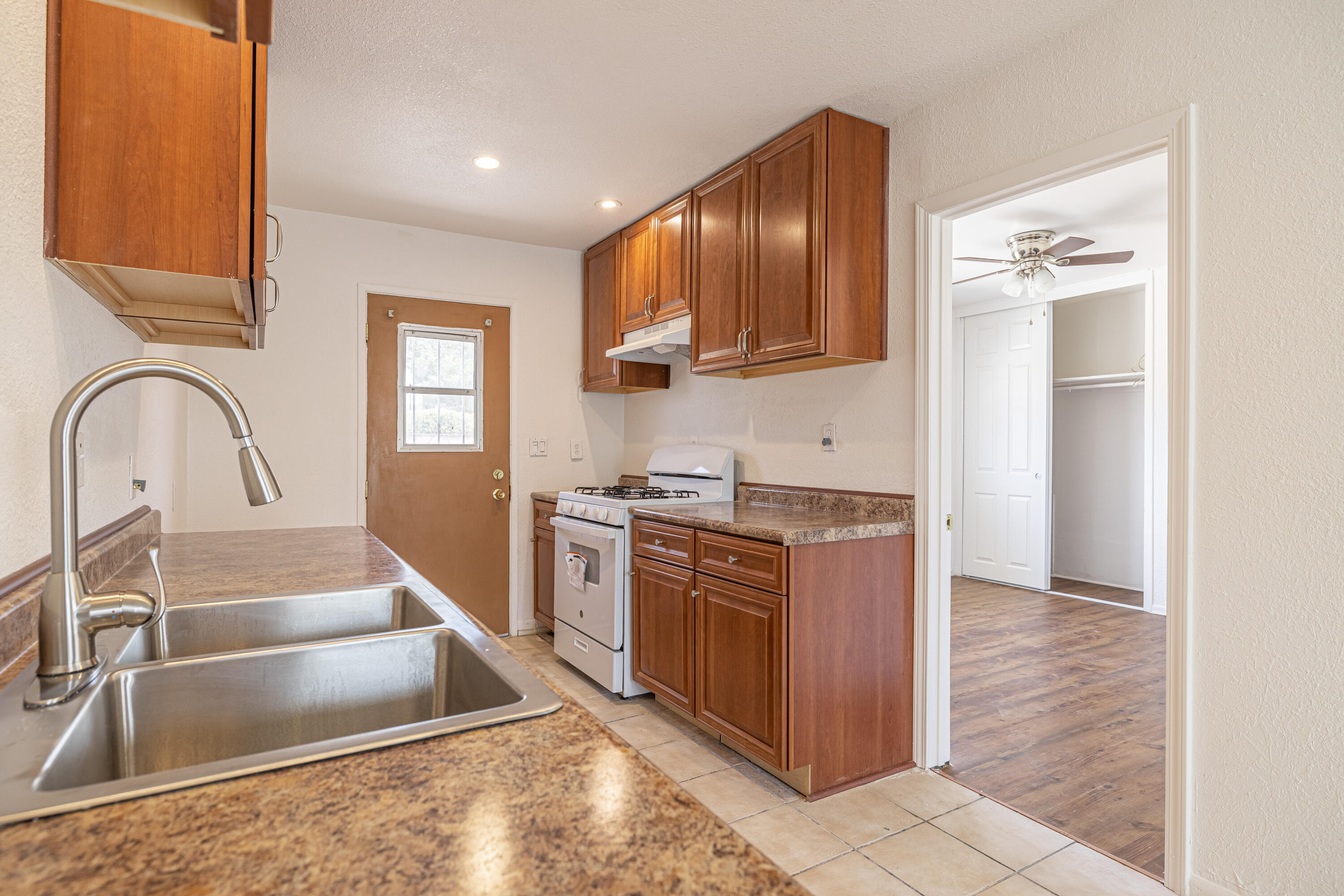 44272 Glenraven Road Lancaster, CA 93535 - Photo 9 of 21 a kitchen with stainless steel appliances granite countertop a sink and a stove top oven