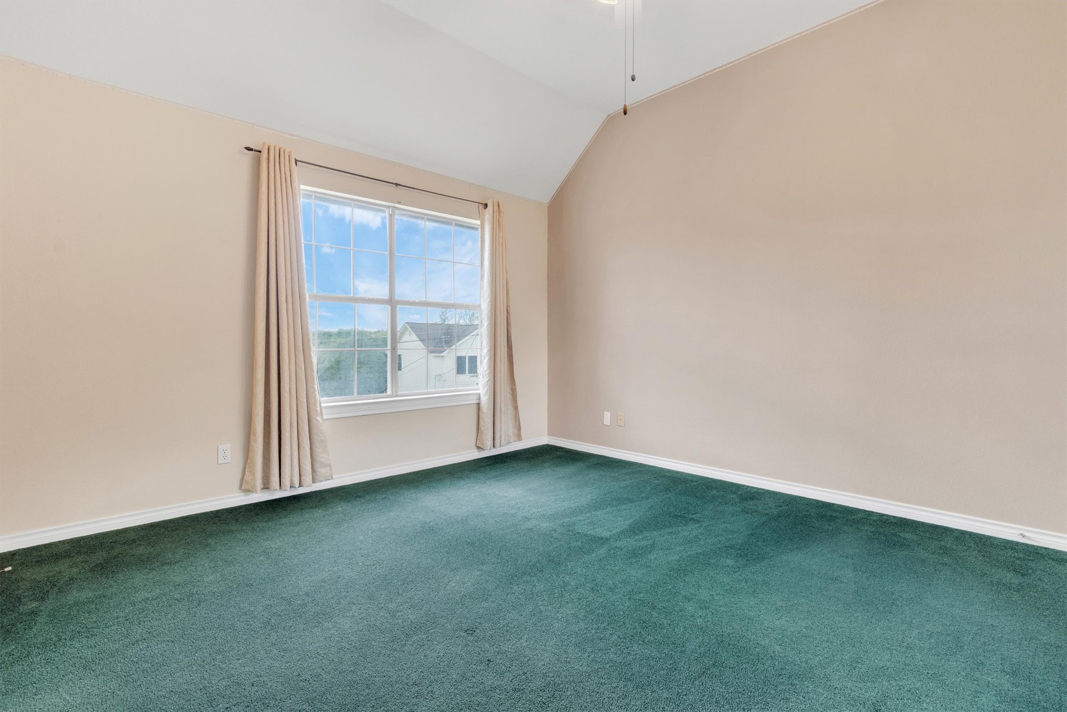1207 Orlando Road Austin, TX 78733 - Photo 14 of 30 Vaulted ceiling with ceiling fan, large window with natural light, wall-to-wall carpeting, and neutral wall tones