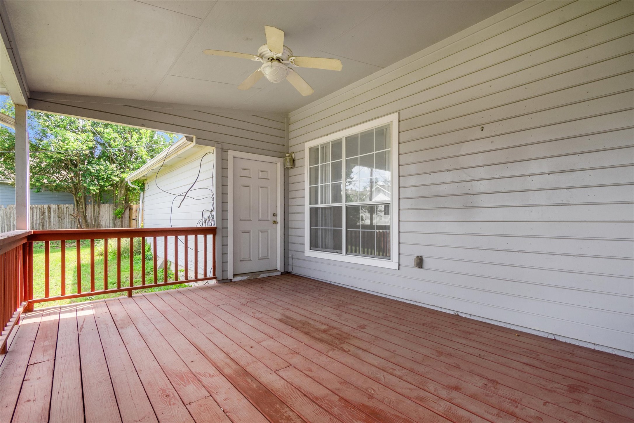 1207 Orlando Road Austin, TX 78733 - Photo 23 of 30 Covered outdoor patio featuring wood-finish decking, light gray horizontal siding, and a ceiling fan