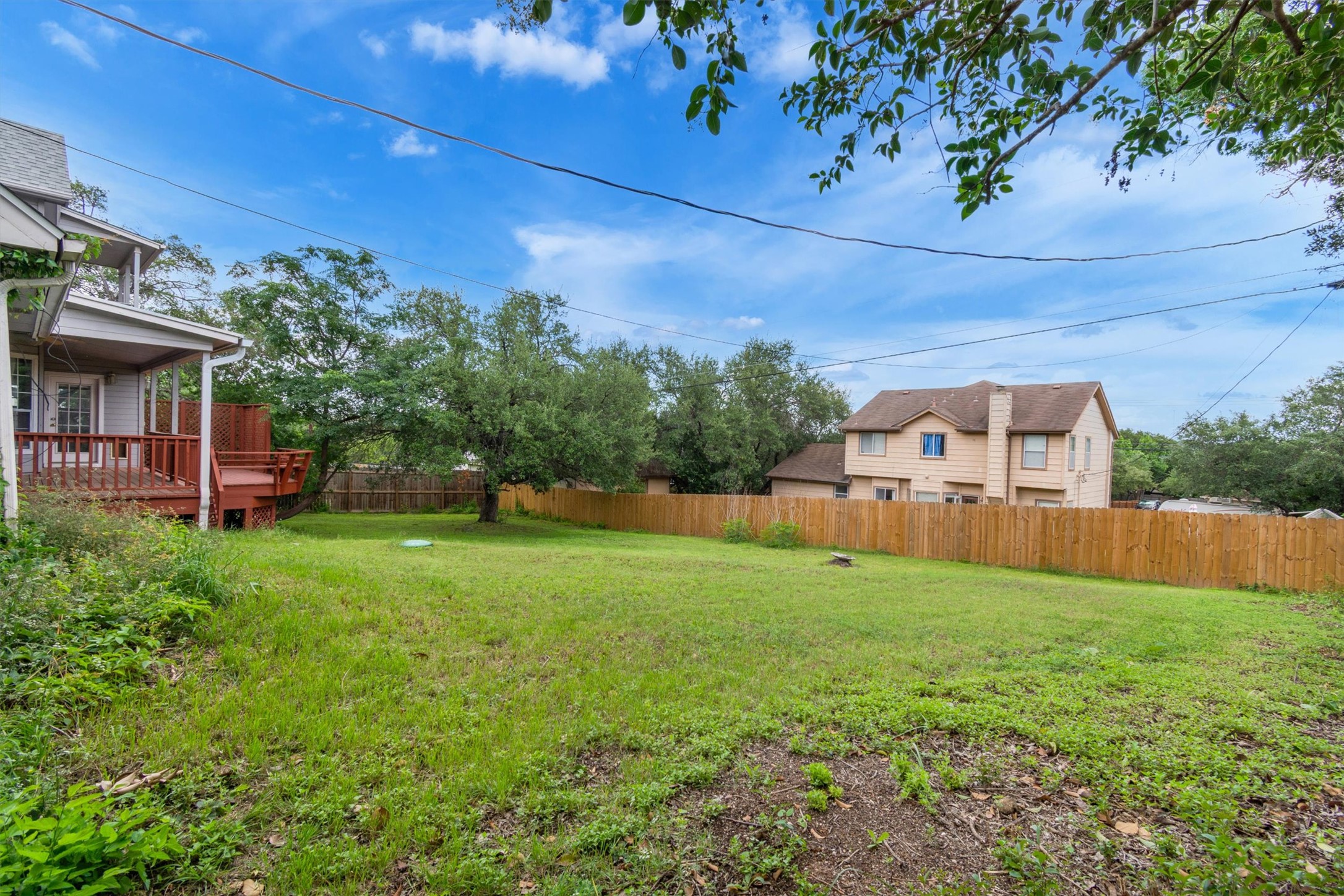 1207 Orlando Road Austin, TX 78733 - Photo 28 of 30 Expansive backyard featuring a large grassy area, privacy fencing, and mature trees