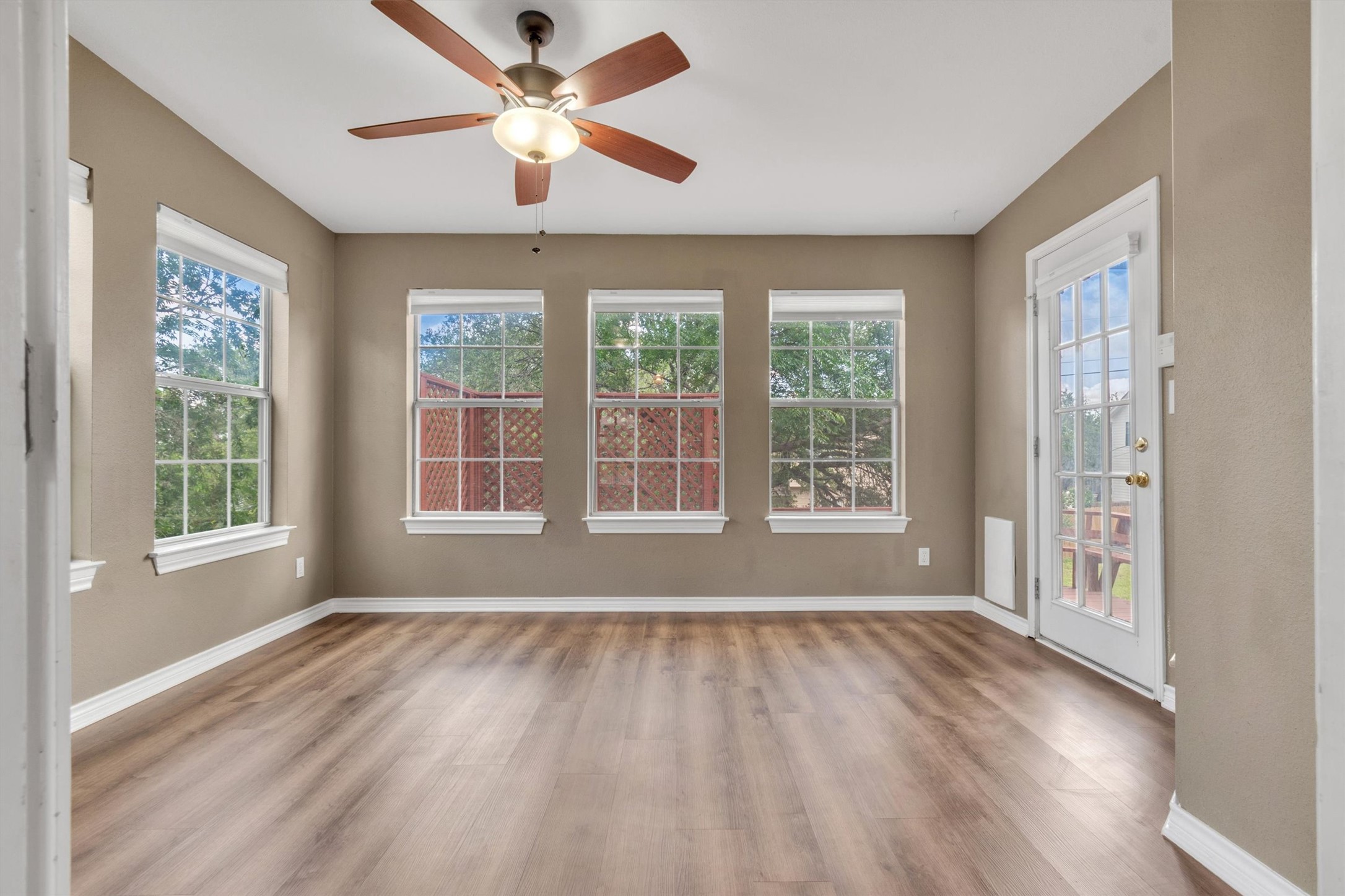 1207 Orlando Road Austin, TX 78733 - Photo 5 of 30 Spacious room featuring wood-finish flooring, neutral-toned walls, and a ceiling fan with integrated lighting