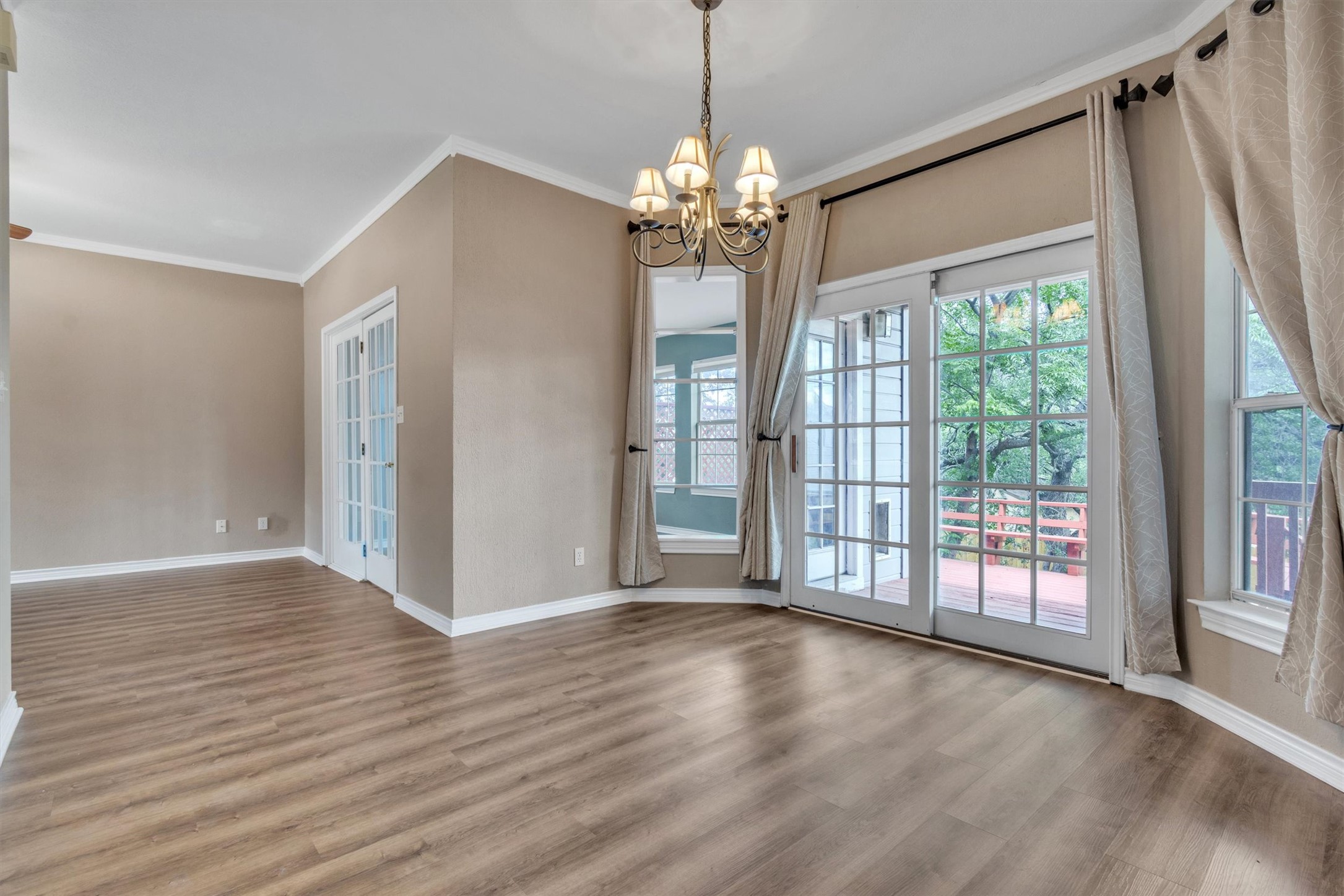 1207 Orlando Road Austin, TX 78733 - Photo 7 of 30 Spacious room featuring wood-finish flooring, crown molding, and neutral wall tones