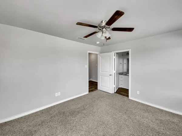 an empty room with closet and fan