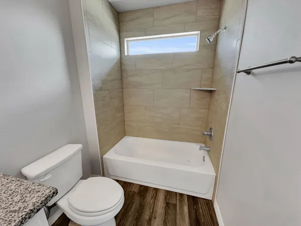 a white toilet sitting next to a bath tub