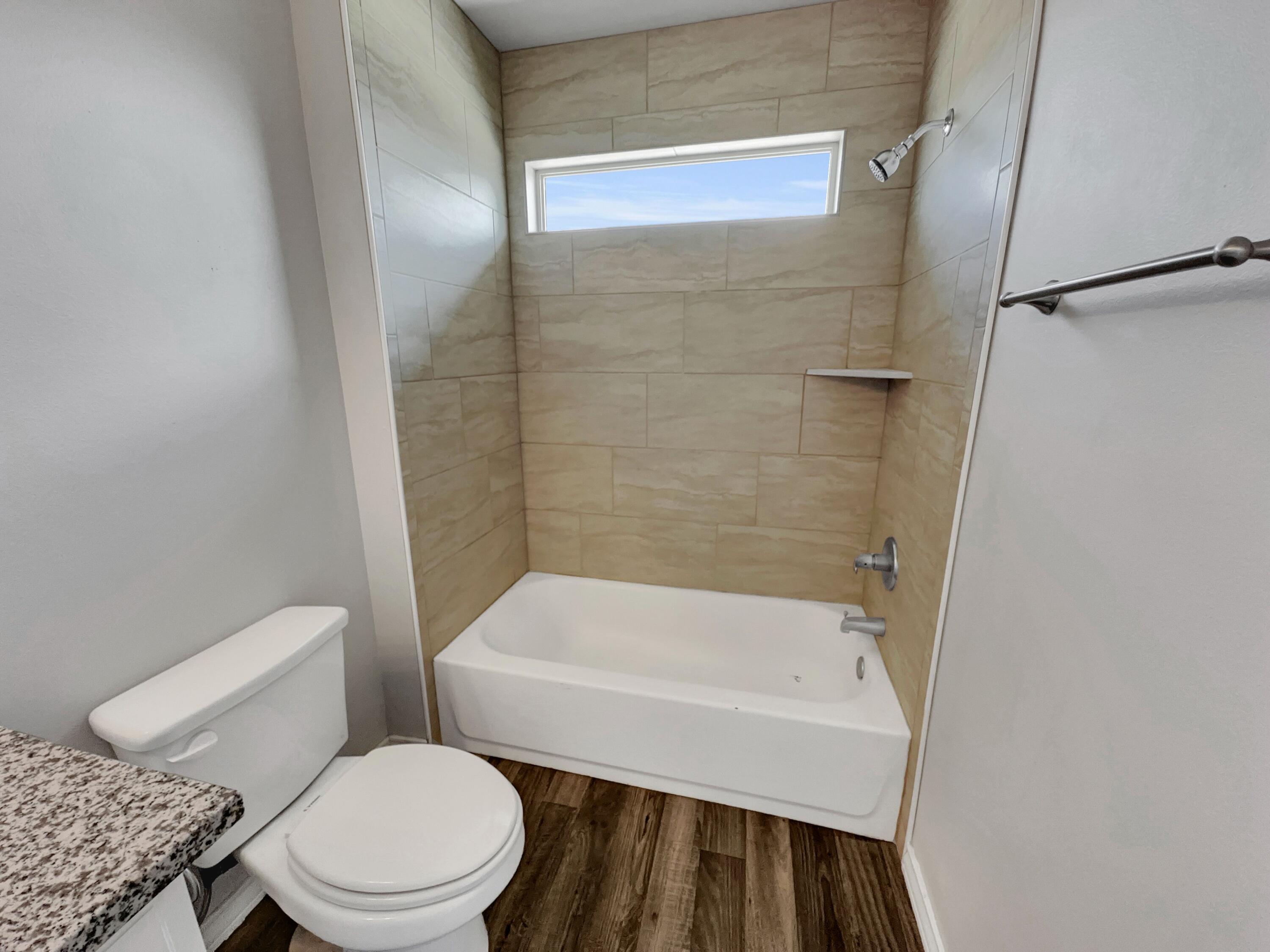 6040 24th Street, Unit 41 Lubbock, TX 79407 - Photo 7 of 12 a white toilet sitting next to a bath tub
