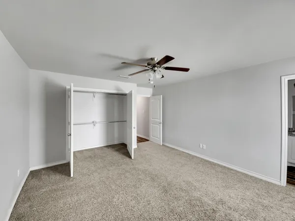 a view of an empty room with a ceiling fan
