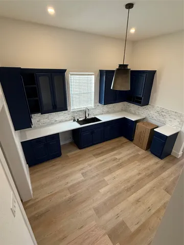 a kitchen with a stove and a wooden floor