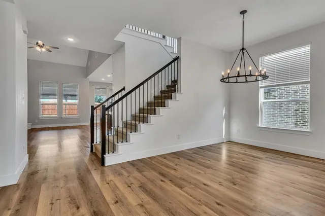 a view of a hallway with wooden floor and staircase