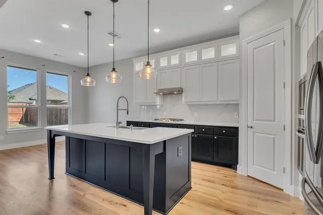 a kitchen with a sink a counter space appliances and cabinets