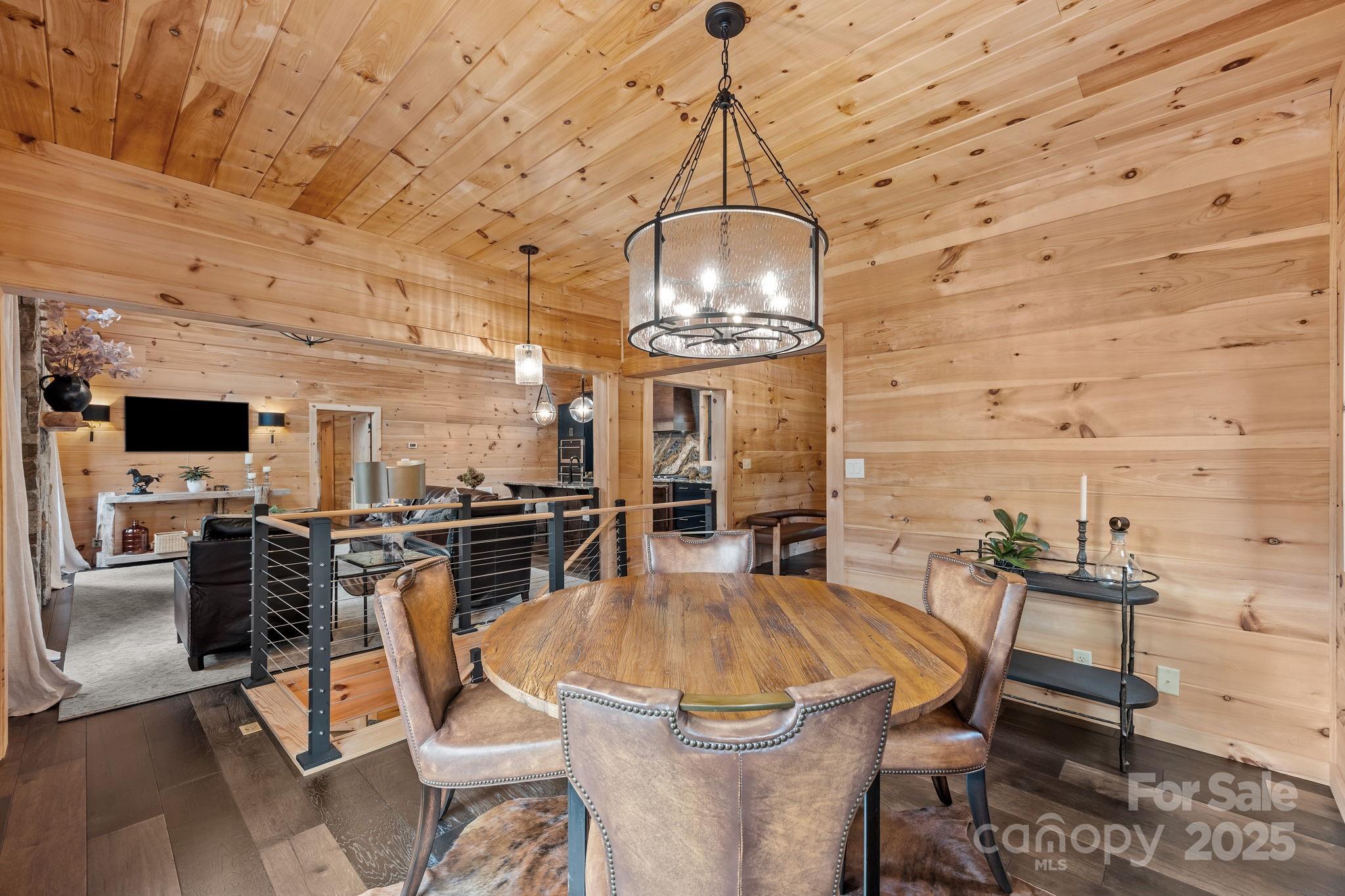 91 Boone Cove Road Zirconia, NC 28790 - Photo 16 of 48 a view of a dining room with furniture a chandelier and wooden floor
