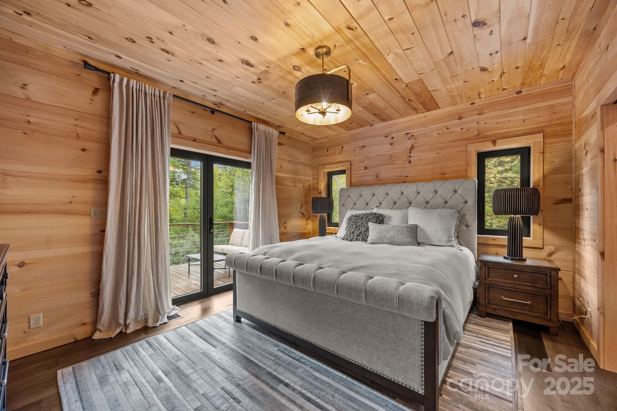 91 Boone Cove Road Zirconia, NC 28790 - Photo 19 of 48 a bedroom with a bed wooden floor and window
