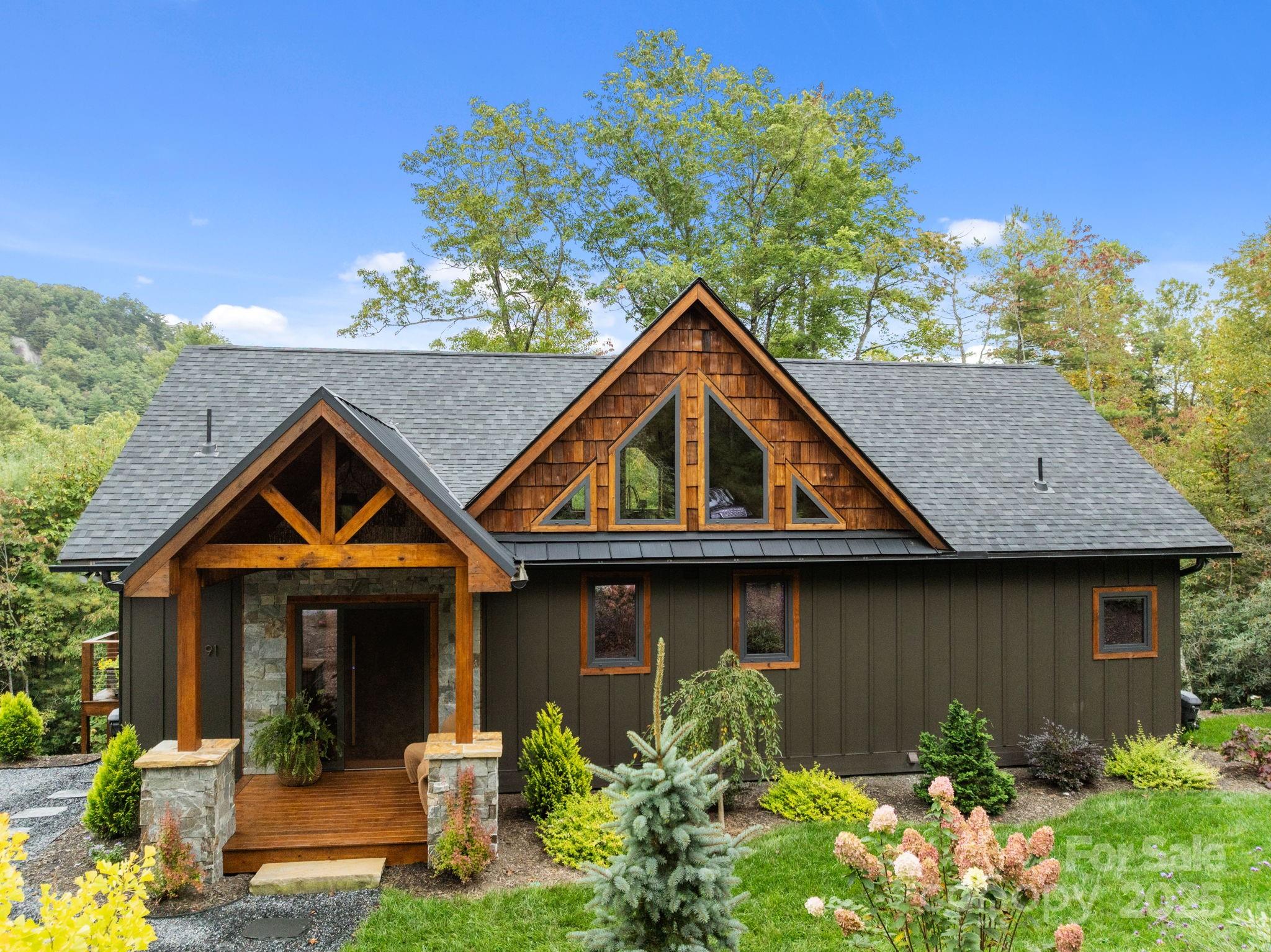 91 Boone Cove Road Zirconia, NC 28790 - Photo 2 of 48 a front view of a house with garden