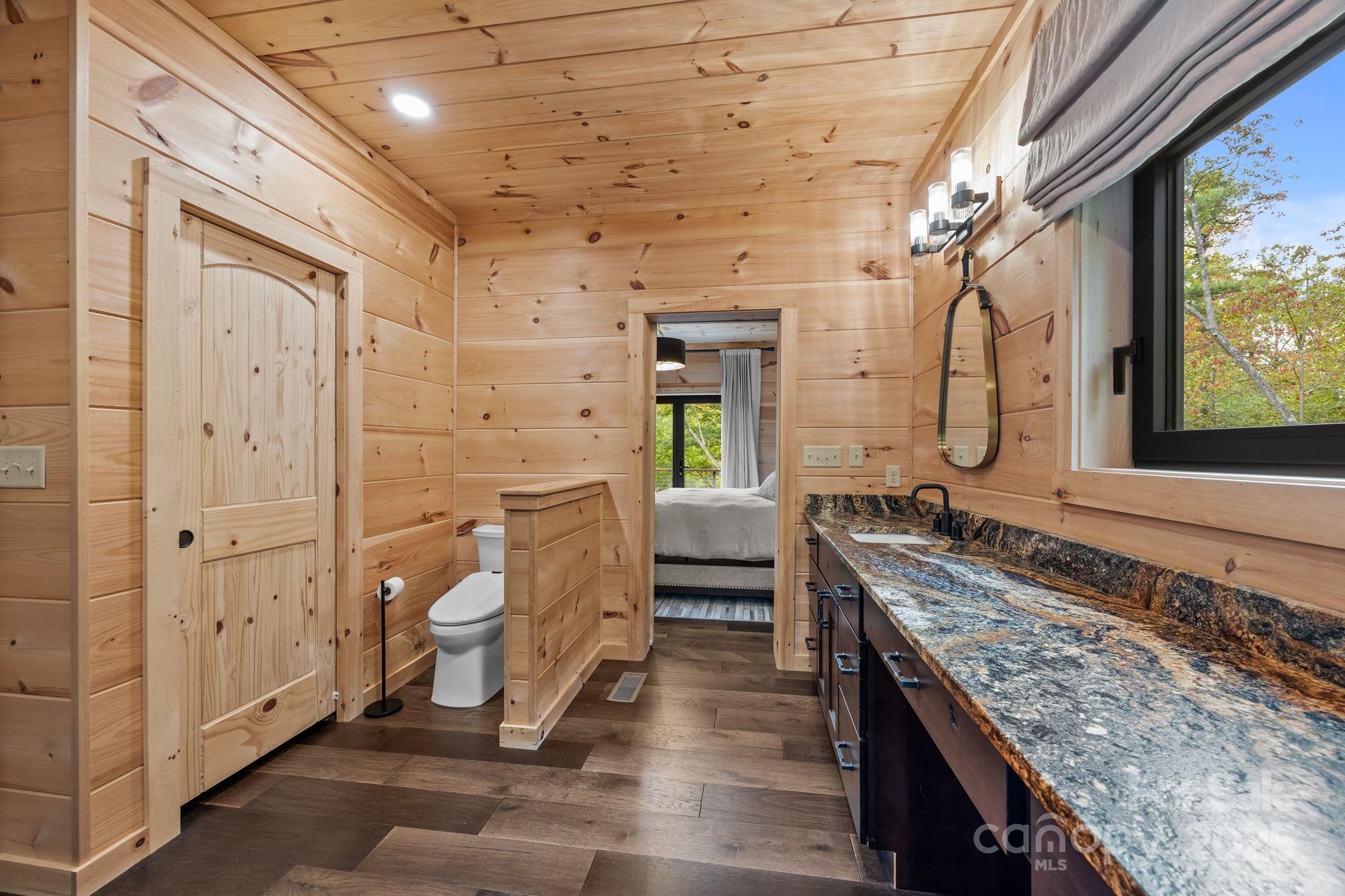 91 Boone Cove Road Zirconia, NC 28790 - Photo 24 of 48 a spacious bathroom with a granite countertop sink and a mirror