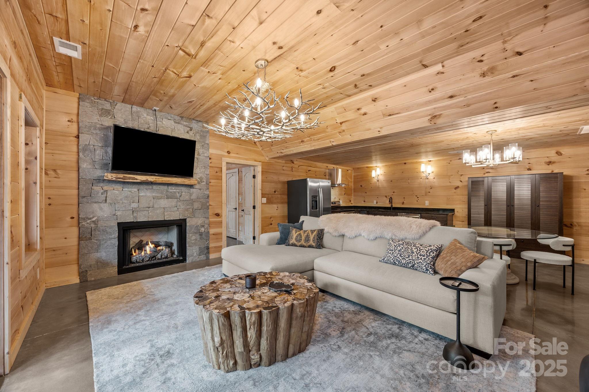 91 Boone Cove Road Zirconia, NC 28790 - Photo 26 of 48 a living room with furniture a flat screen tv and a fireplace