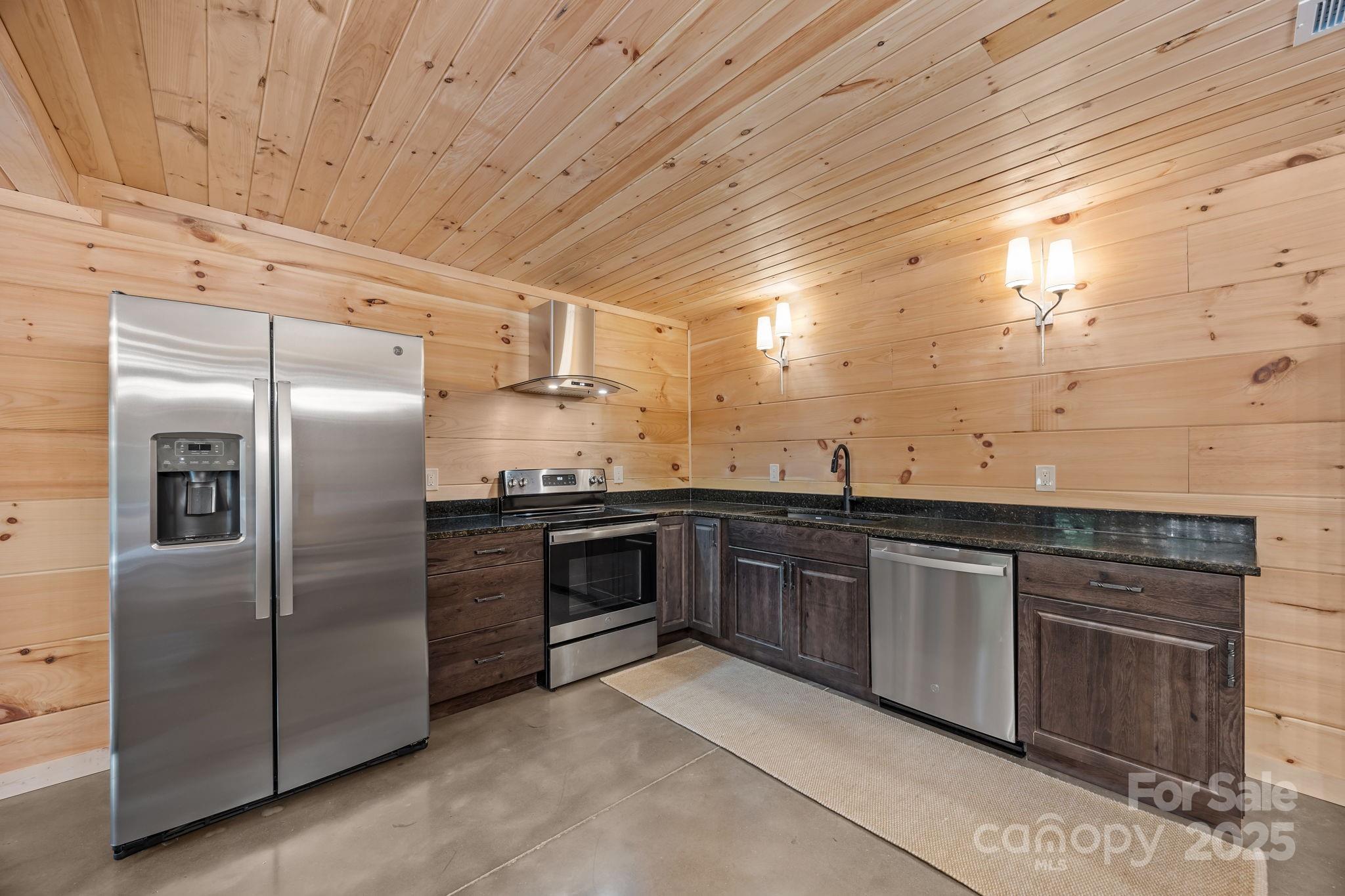 91 Boone Cove Road Zirconia, NC 28790 - Photo 28 of 48 a kitchen with granite countertop stainless steel appliances and wooden cabinets