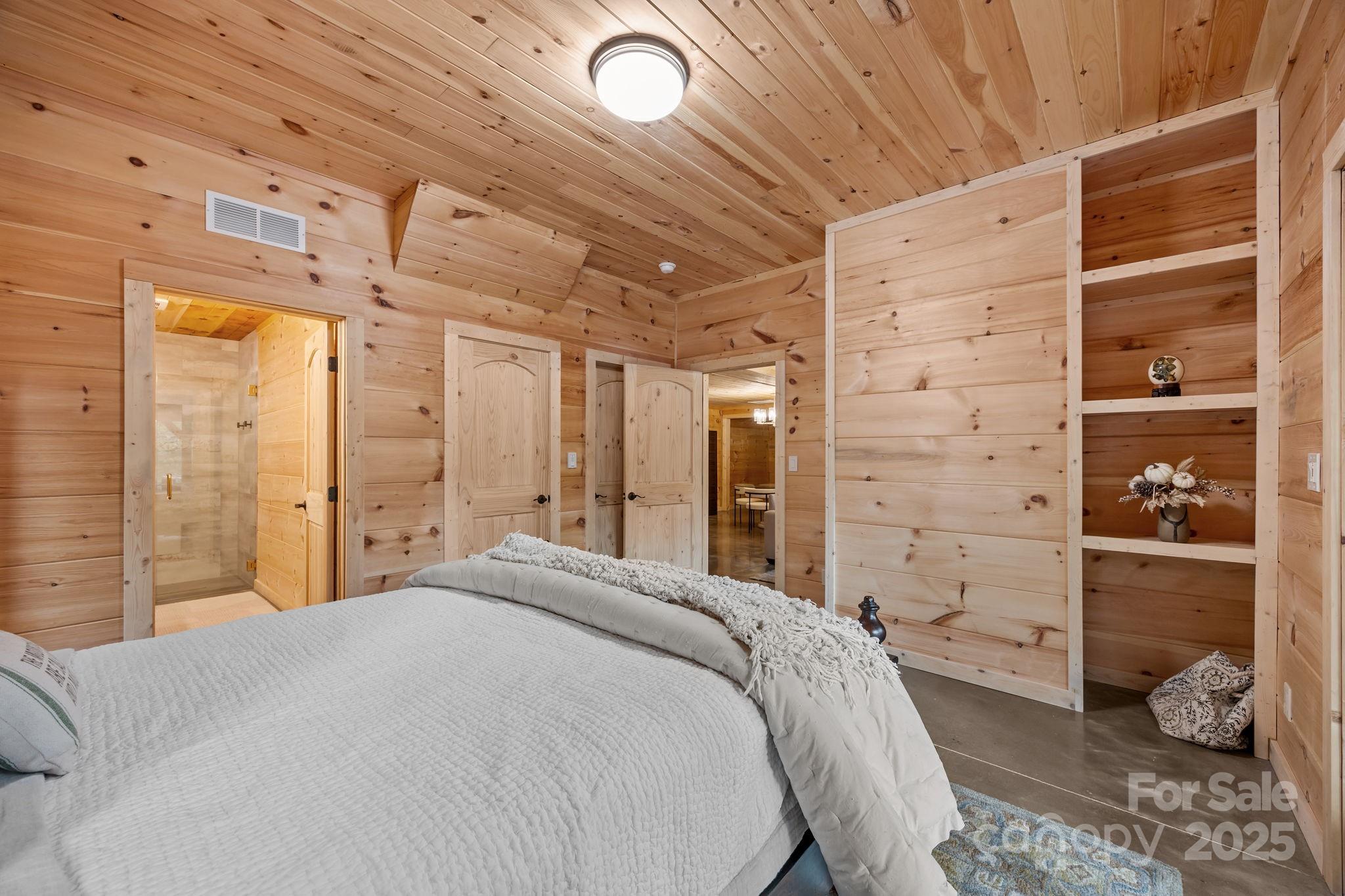 91 Boone Cove Road Zirconia, NC 28790 - Photo 35 of 48 a bedroom with a bed and a walk in closet