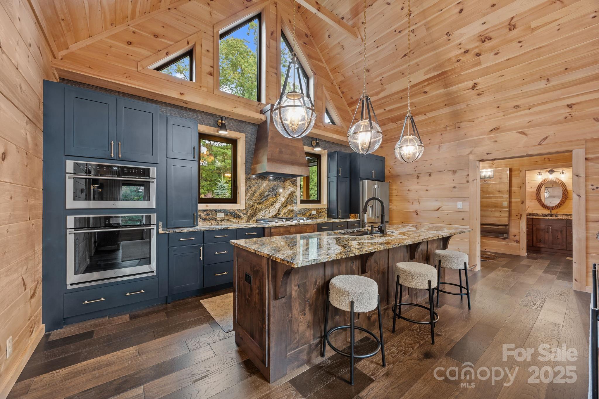 91 Boone Cove Road Zirconia, NC 28790 - Photo 10 of 48 a dining hall with stainless steel appliances kitchen island granite countertop a stove and cabinets