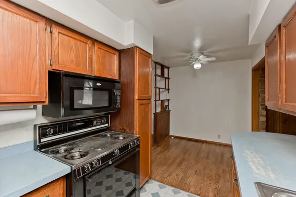 a kitchen with wooden floor and stainless steel appliances
