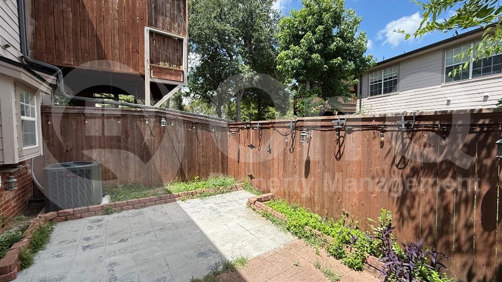 18240 Midway Road, Unit 1204 Dallas, TX 75287 - Photo 21 of 27 Private patio space featuring a paved surface, brick edging, and a tall wood fence