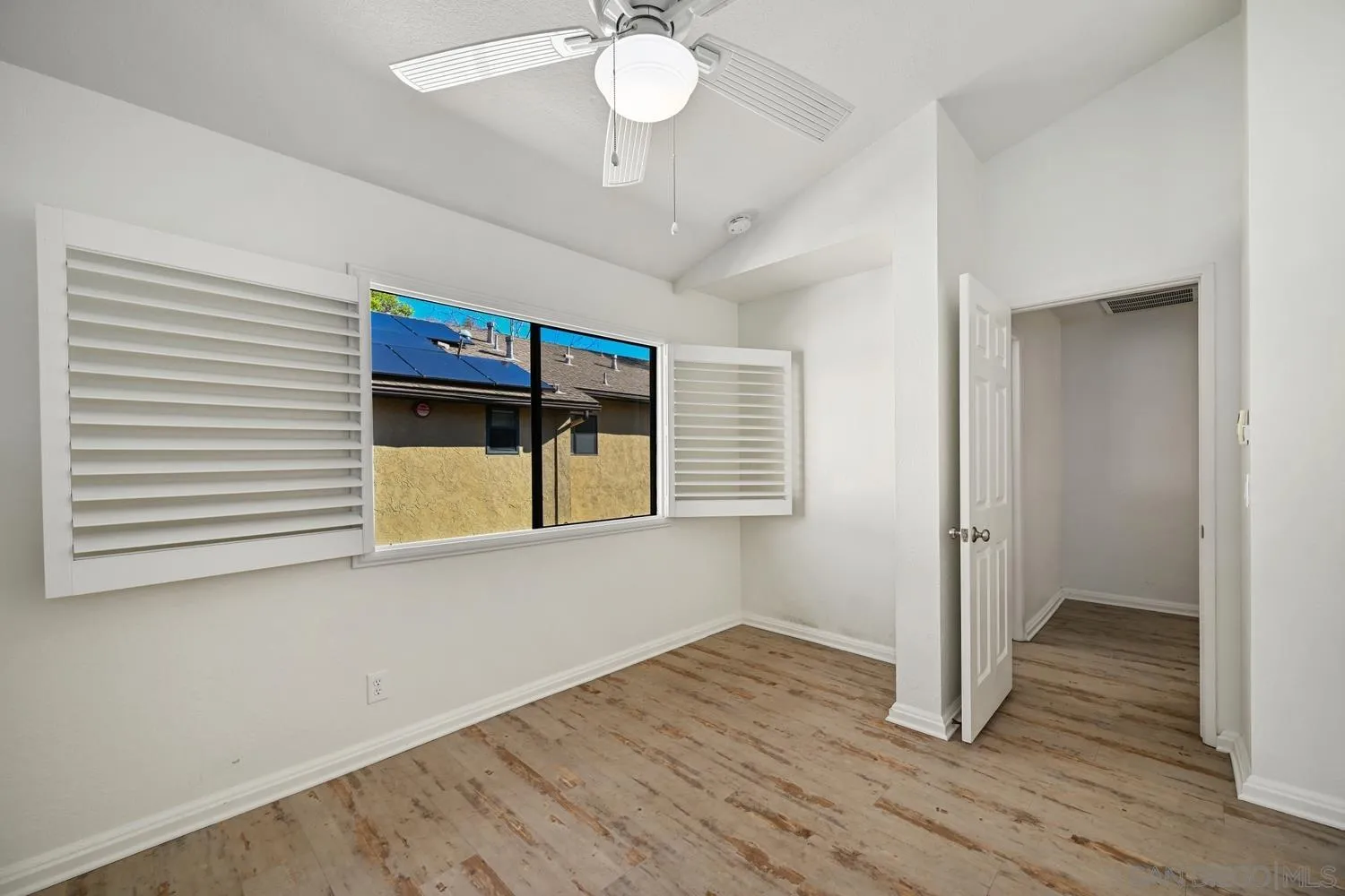 1680 North Coast Highway 101, Unit 30 Encinitas, CA 92024 - Photo 22 of 41 a view of an empty room with wooden floor and a window