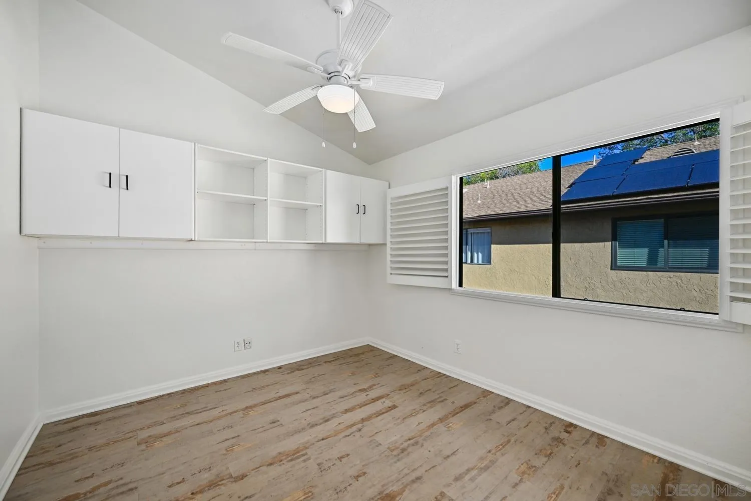 1680 North Coast Highway 101, Unit 30 Encinitas, CA 92024 - Photo 25 of 41 a view of an empty room with wooden floor and a window