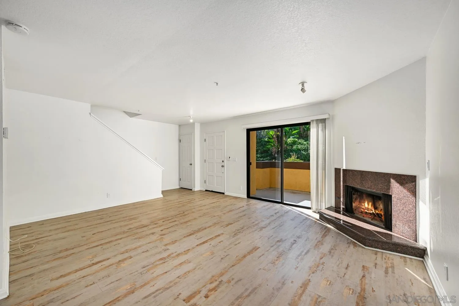 1680 North Coast Highway 101, Unit 30 Encinitas, CA 92024 - Photo 6 of 41 a view of empty room with wooden floor and fireplace