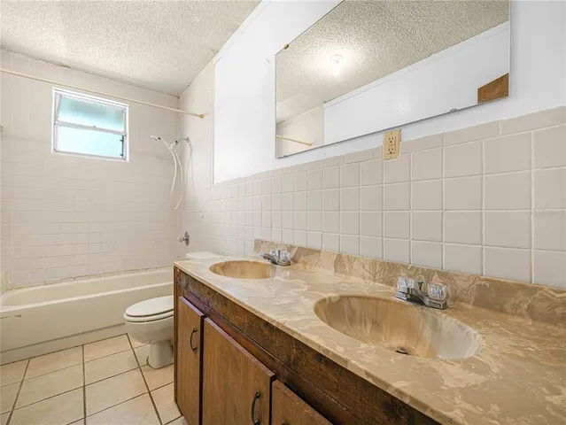 a bathroom with a granite countertop sink a toilet and a bathtub