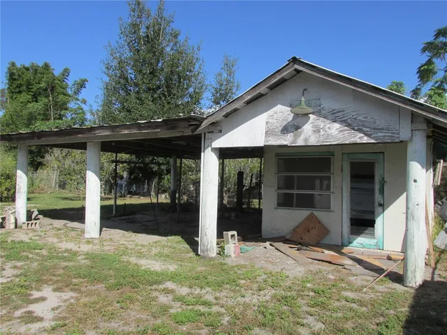 a view of a house with a big yard and large tree
