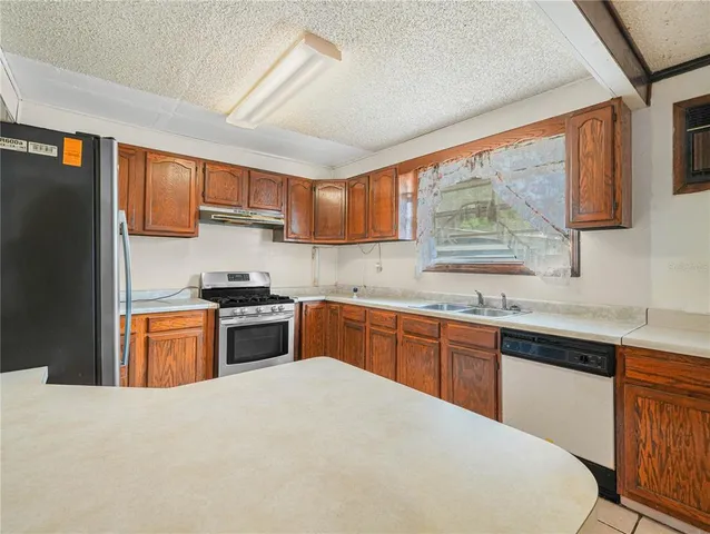 a kitchen with granite countertop a stove top oven sink and cabinets