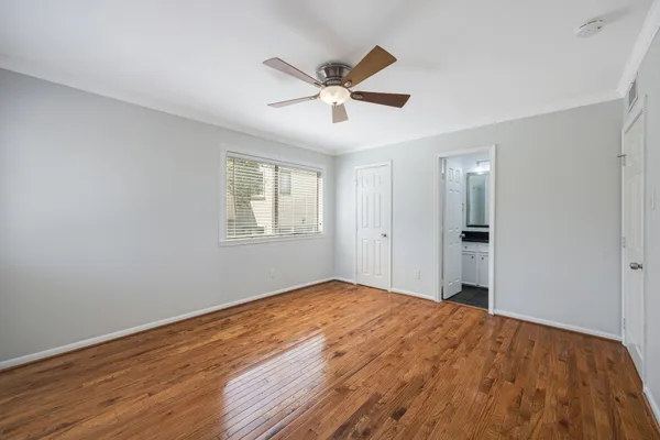 a view of empty room with wooden floor and ceiling fan