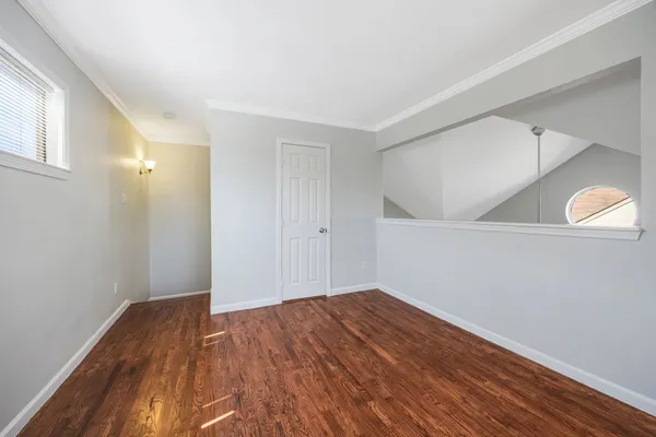 a view of empty room with wooden floor
