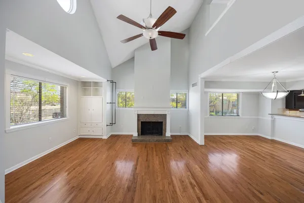 wooden floor fireplace and windows in an empty room